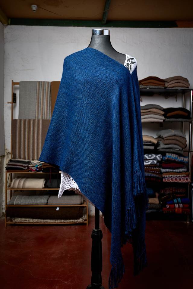 Poncho azul de mujer dispuesto sobre maniquí