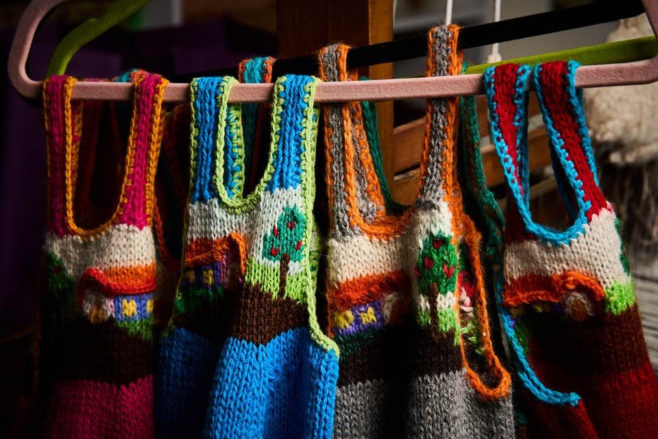Piezas infantiles tejidas y colgadas en la tienda