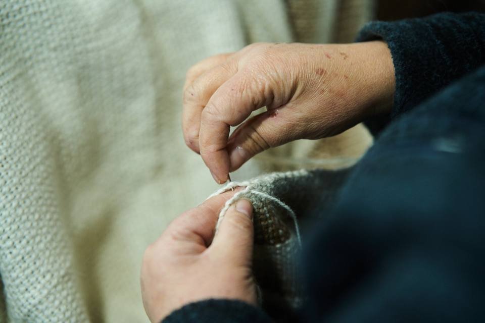 Manos trabajando una pieza tejida